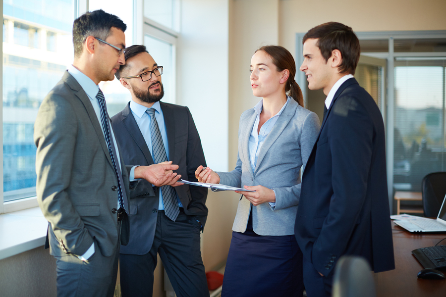 Group of colleagues discussing documents and business plans in office