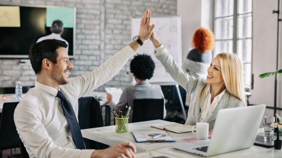 Happy business people supporting each other and giving high five in the office.